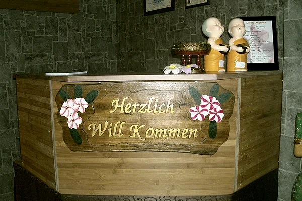 Empfangstresen mit der Schnitzerei Herzlich Will Kommen
