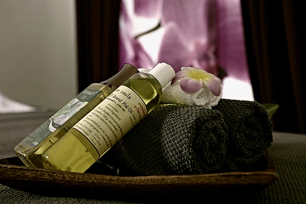 Massageöle, Handtücher und eine Frangipani-Blüte